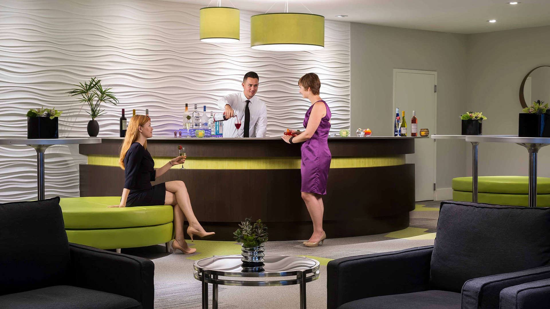 two women at business event bar with bartender